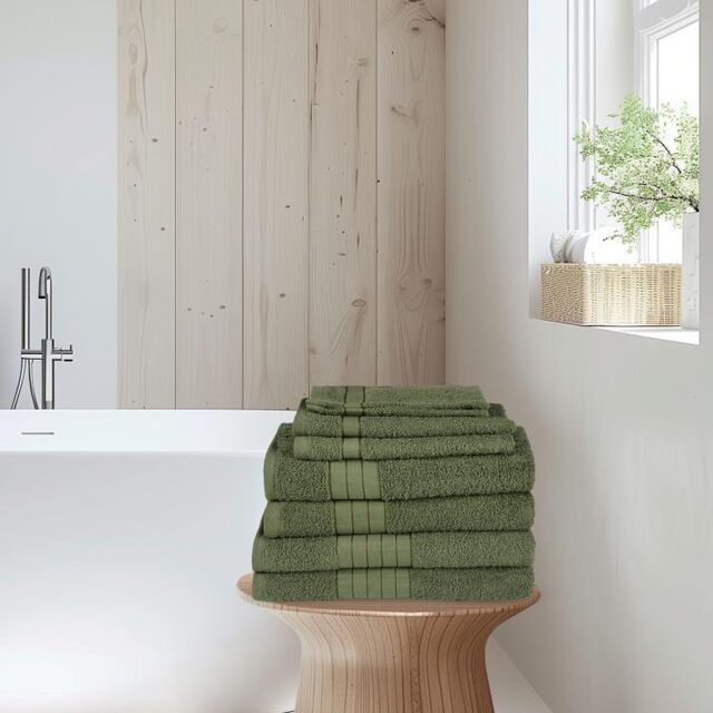 Stapel groene handdoeken op een krukje in een lichte badkamer